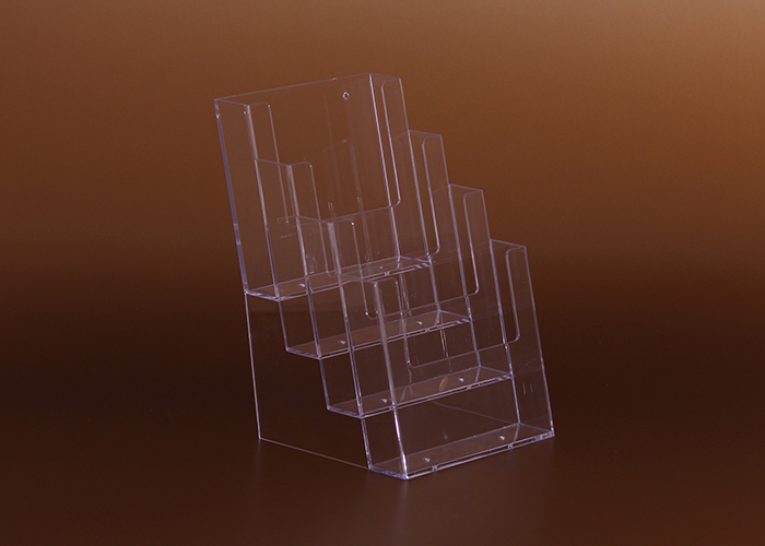 Átlátszó plexiből készült 4 rekeszes asztali szórólaptartó, amely lehetővé teszi többféle szórólap, prospektus és információs anyag rendezett és jól látható megjelenítését irodákban, recepciókon, üzletekben és kiállításokon.