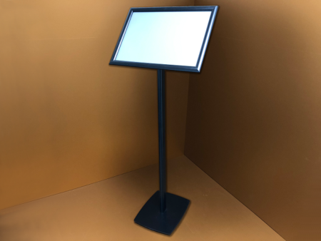 Fém lábra szerelt várakoztató tábla pattintó alumínium keretes plakáttartóval, amely stabil és könnyen használható megoldást biztosít információk, tájékoztatók és ajánlatok esztétikus bemutatására irodákban, üzletekben, várótermekben és közösségi terekben.