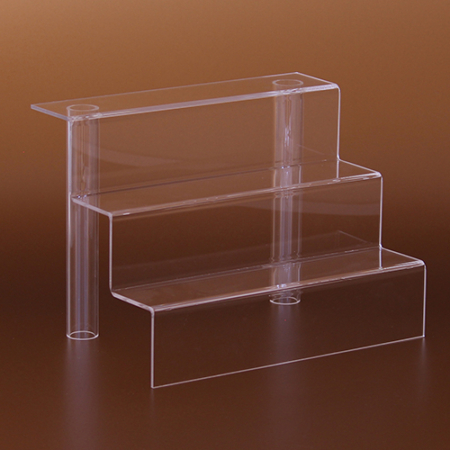 Átlátszó plexiből készült oszlopos, háromszintes kirakati lépcső. A plexi áruemelők, termékállványok, tárgykiemelők kiválóan használhatóak, termékek bemutatására üzletben, bemutatóteremben, kirakatban, vitrinben, kiállításokon vagy rendezvényeken.